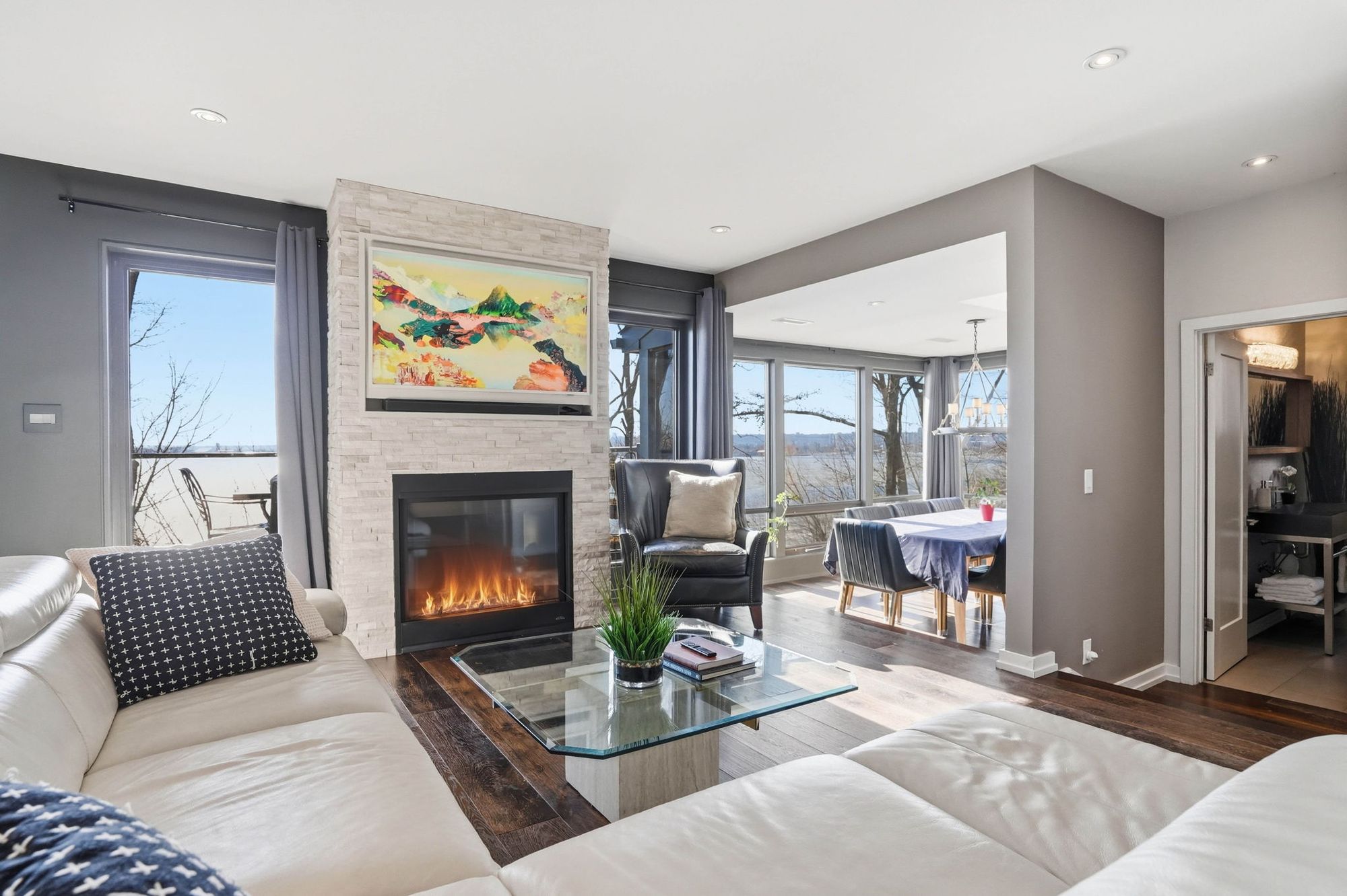 The living room and its fireplace with the bay through the windows