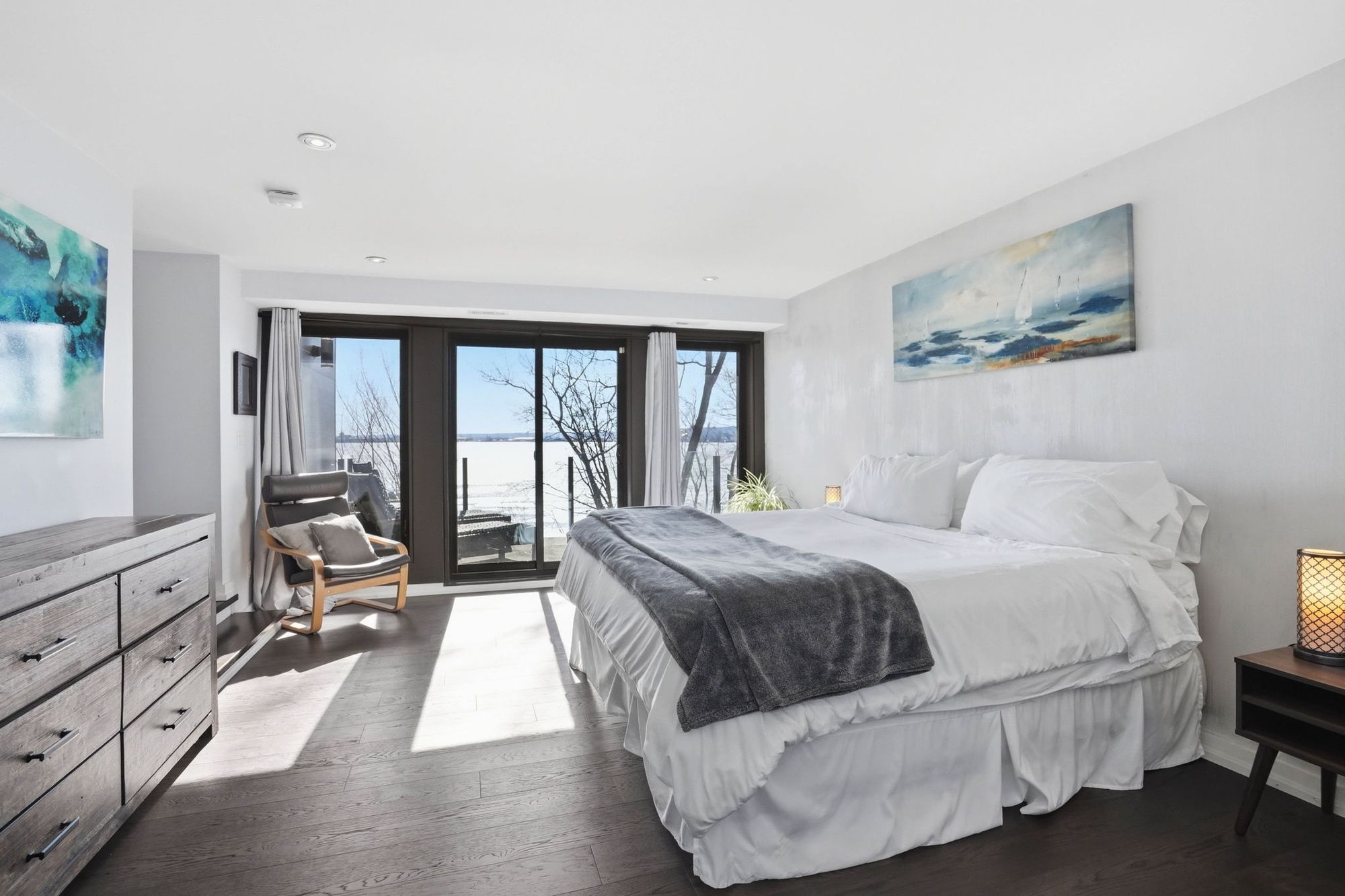 The primary suite with doors to the balcony and the water beyond