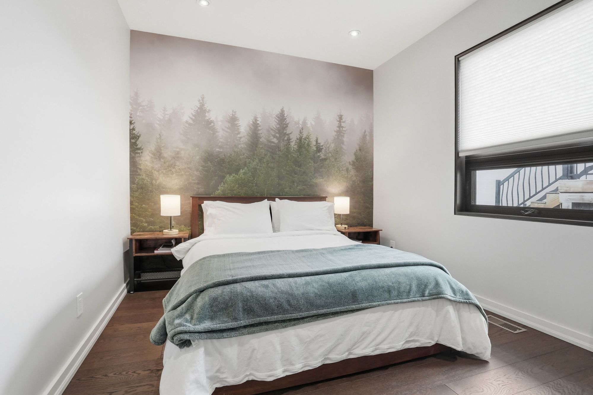 A bedroom with a forest mural