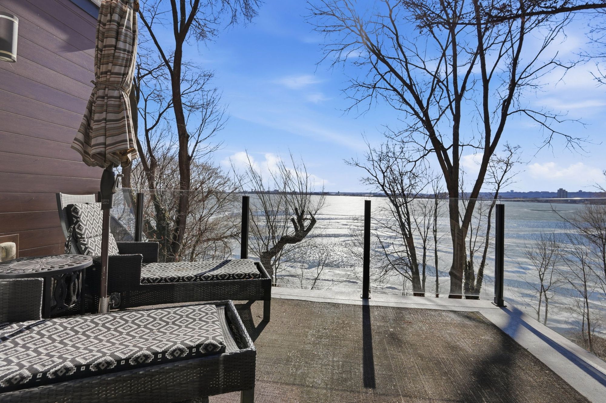Lounge chairs on a covered deck facing the water