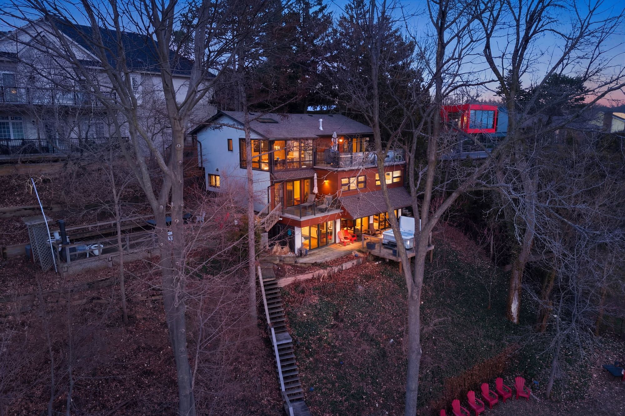 The house and the hillside lit at dusk, from the air