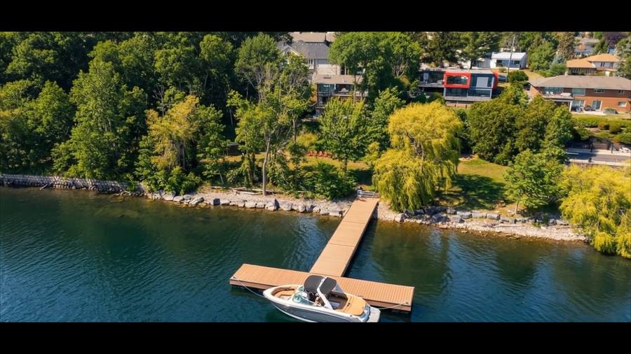 The shoreline below the house on a summer afternoon, from the air (still from the property film)